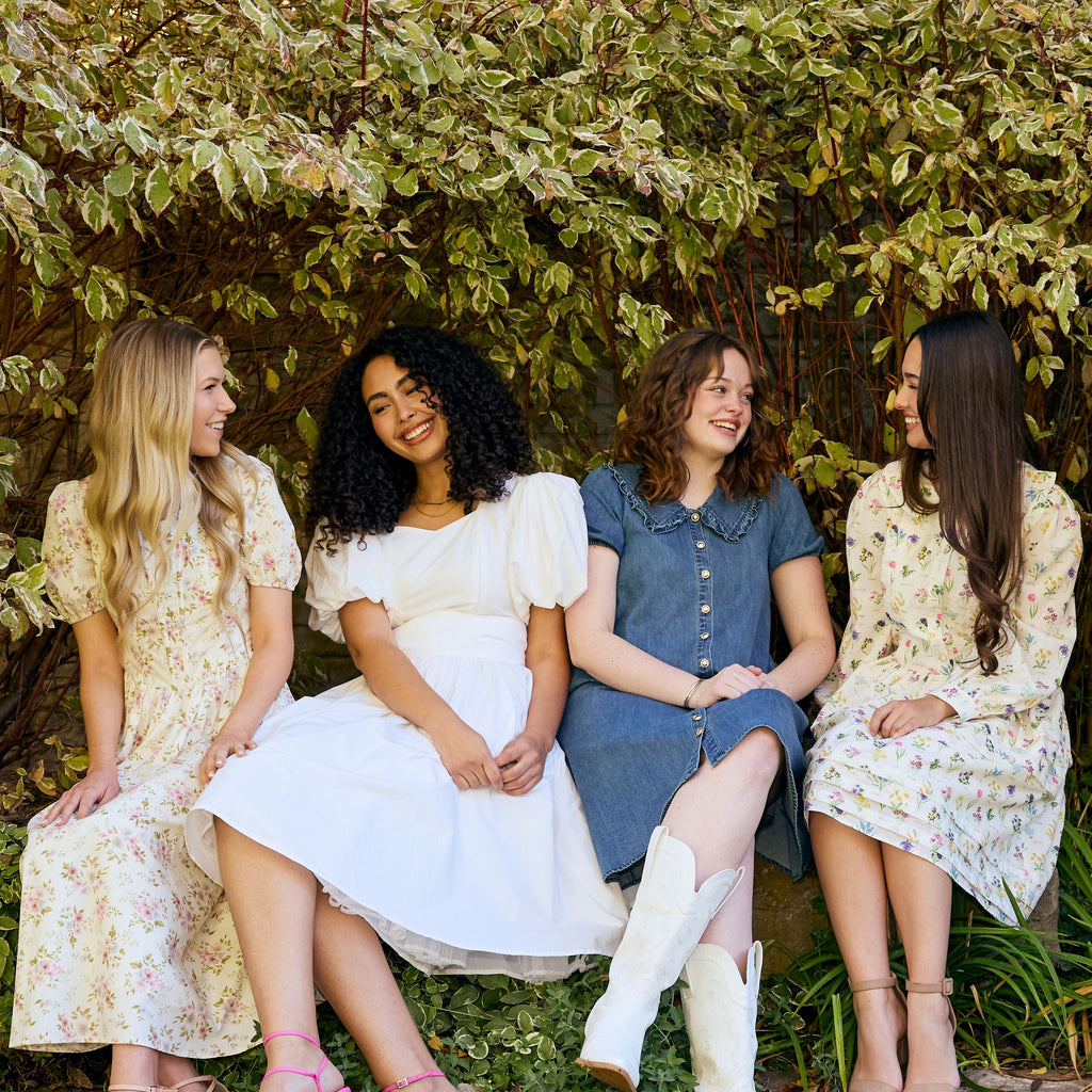 Four women sitting together in a garden setting