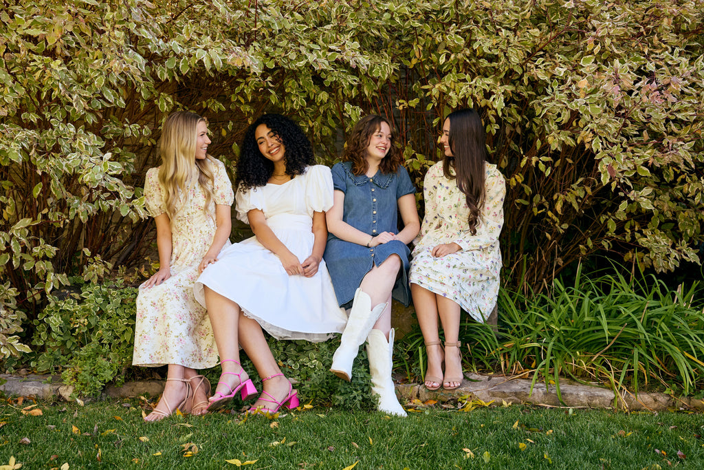 Four women sitting together in a garden setting